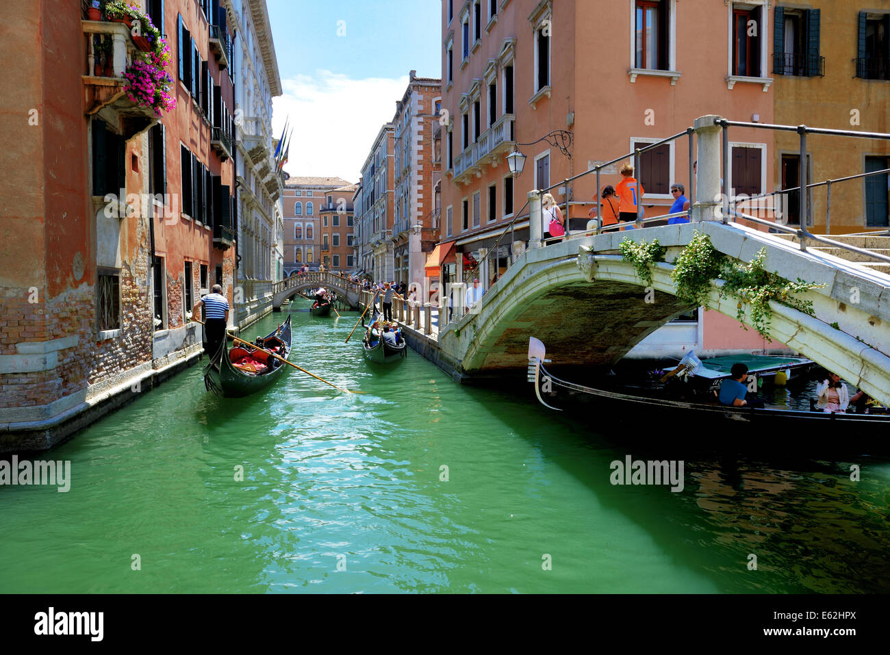 The gondolas with tourists are on water channel, Venice, Italy Stock Photo