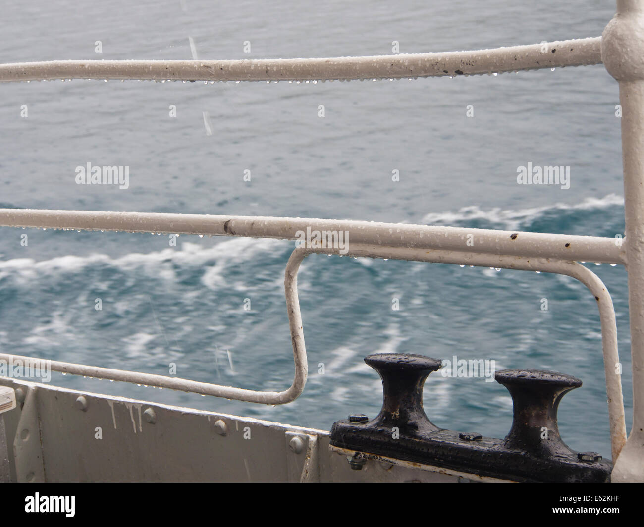 Close up of railing with bollards on a passenger boat crossing a Norwegian mountain lake in rain Stock Photo