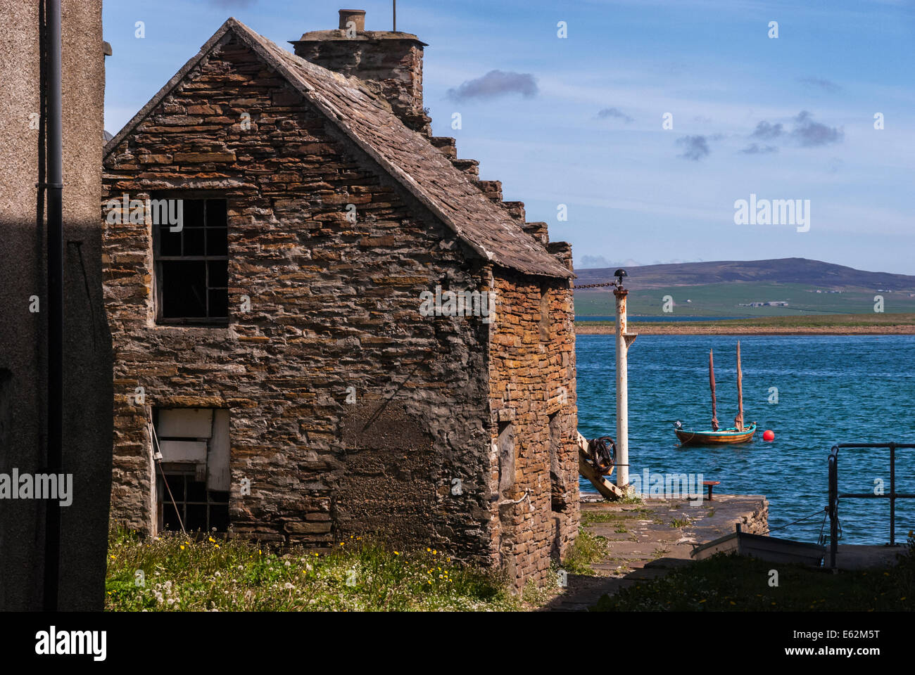 Looking down an alley towards Stromness harbour, from Alfred street, with a two masted cutter in the background Stock Photo