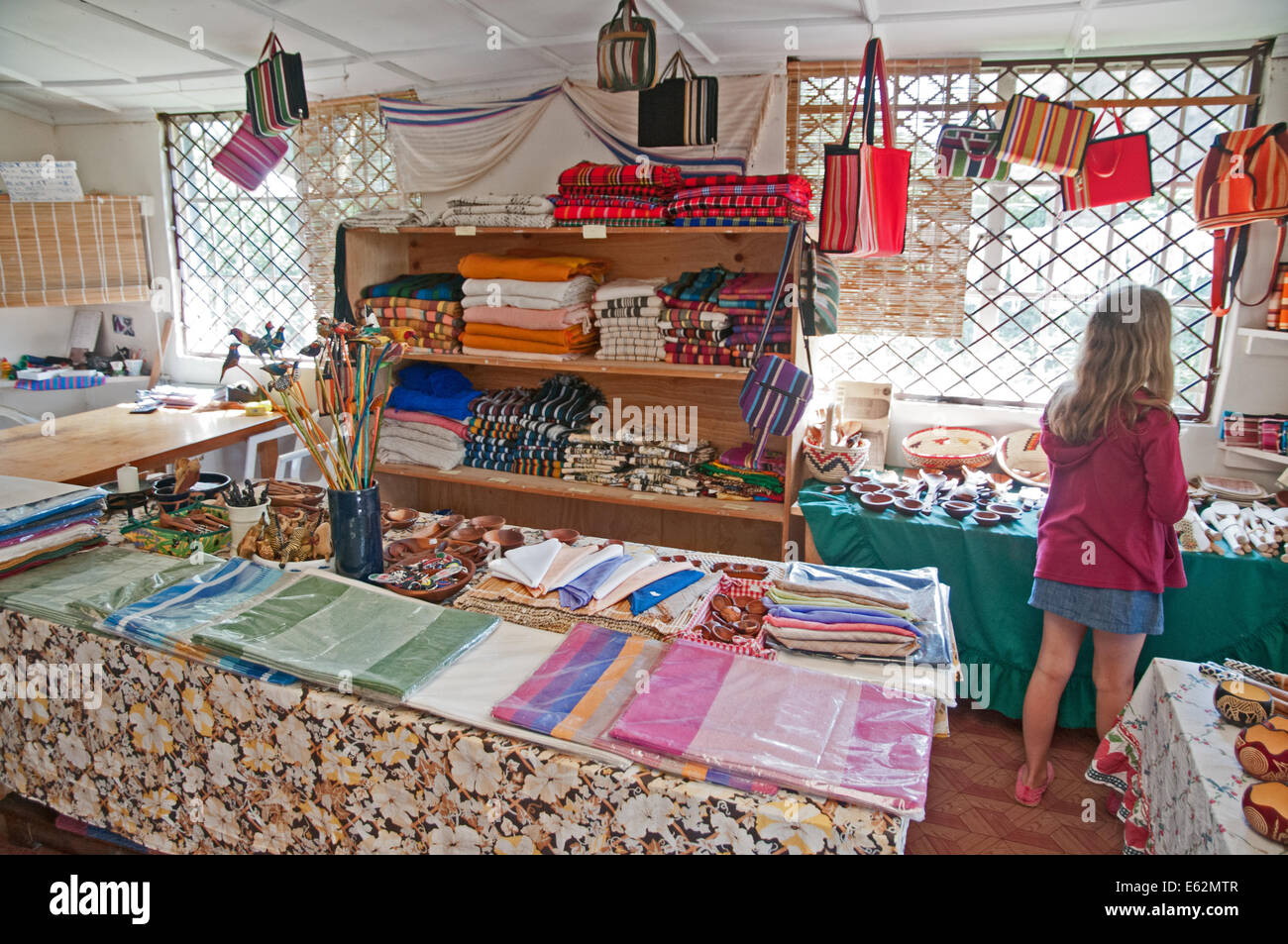 Young girl inside shop or duka of Elmentieta Weavers selling fabrics on Lake Road Naivasha Kenya Africa Stock Photo