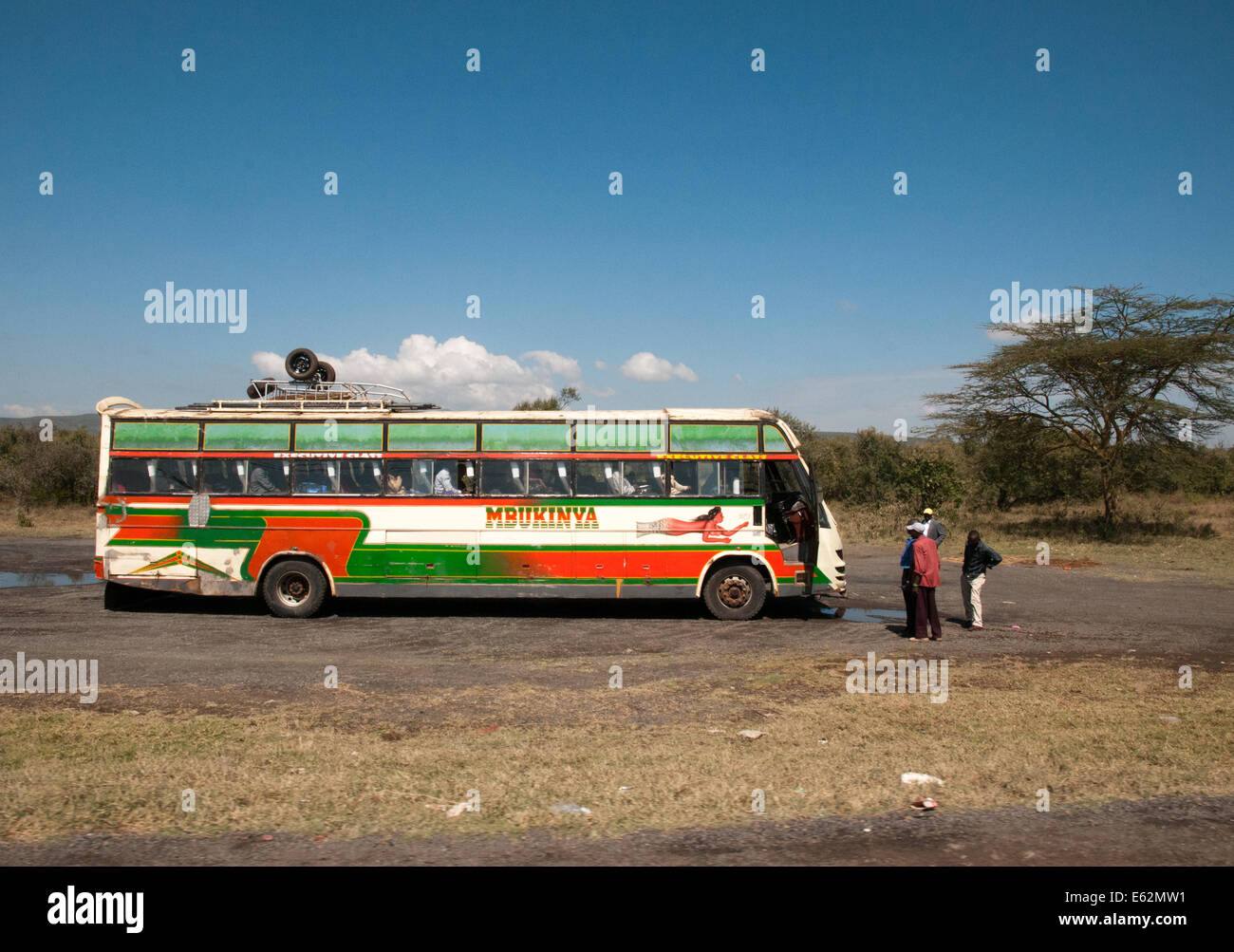 Broken down single decker bus long distance coach with driver outside worrying on Naivasha Nakuru road Kenya Africa Stock Photo