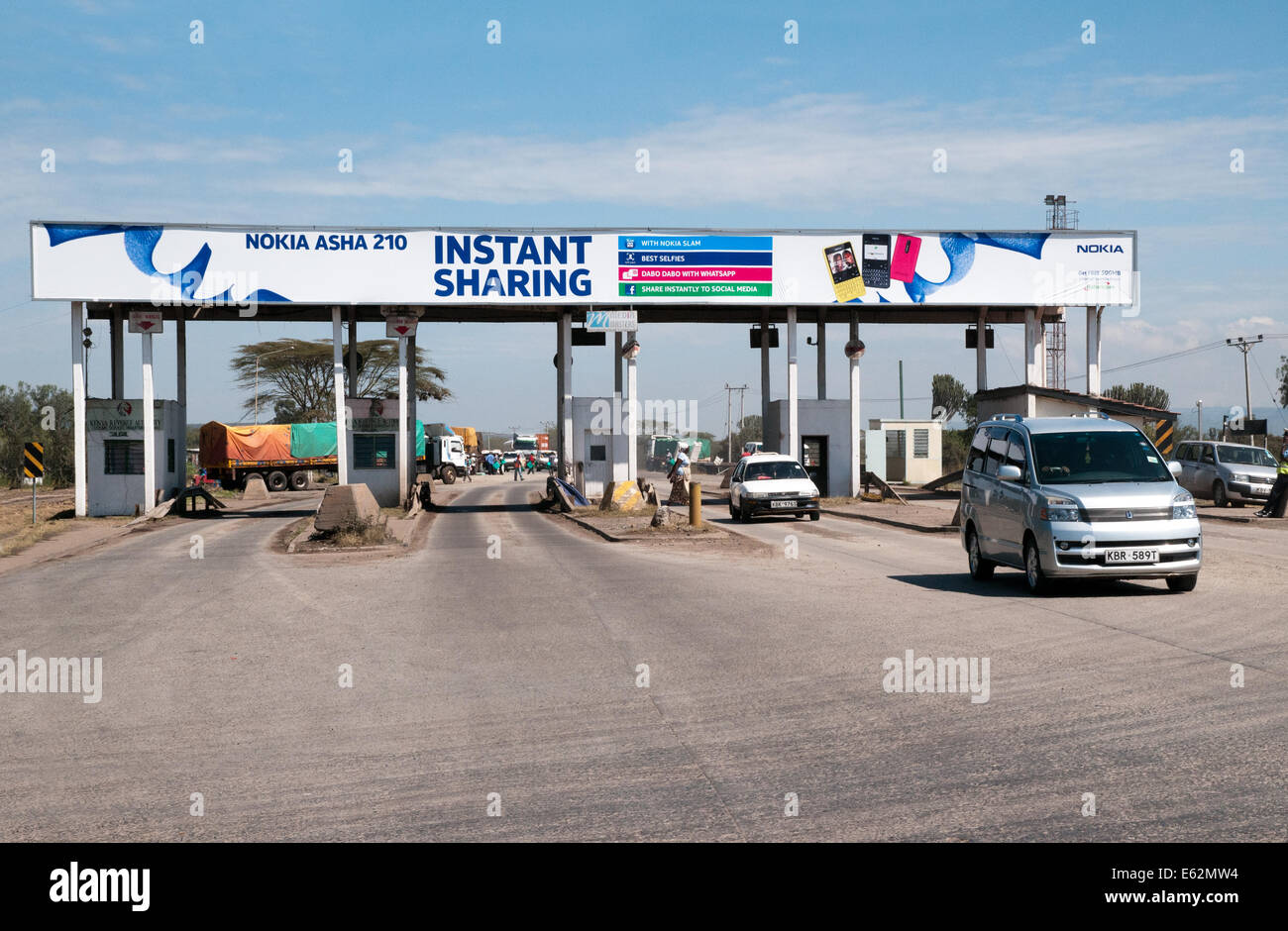 Traffic passing through disused toll station on Trans Africa Highway between Naivasha and Nakuru Kenya East Africa  TRANS AFRICA Stock Photo