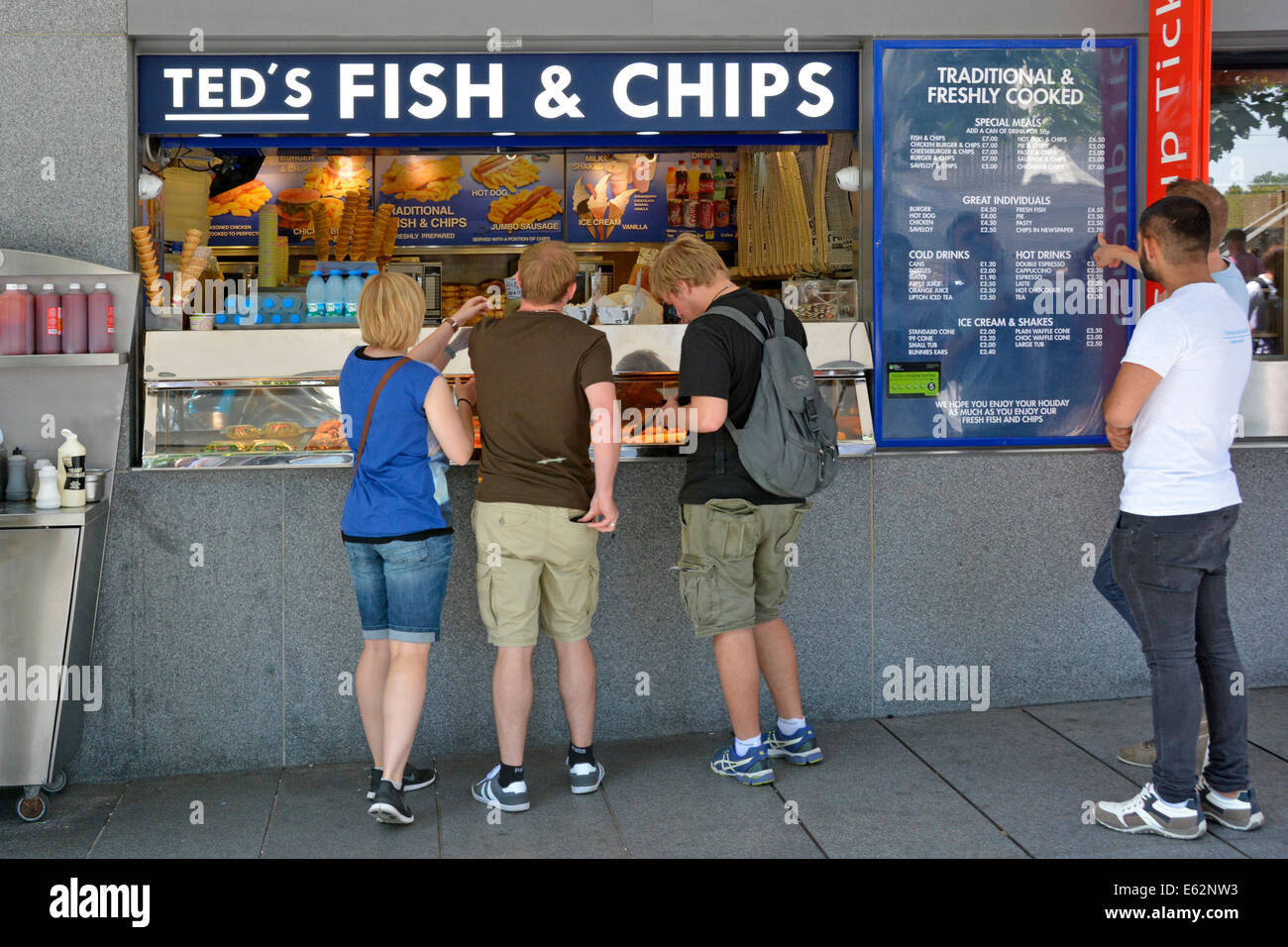 Teds Fish and Chips shop counter back view tourist group customers shopping for traditional British food by people visiting Tower of London England UK Stock Photo
