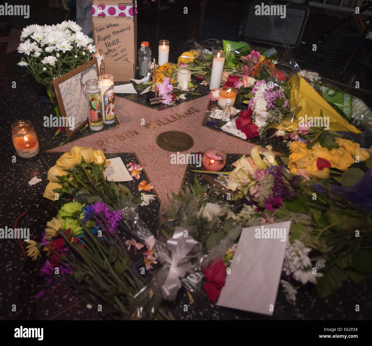 Hollywood, California, USA. 12th Aug, 2014. Fans, mourners and tourists began to leave candles, flowers and cards along Hollywood Blvd. and the Hollywood Walk of fame just east of the TCL Chinese Theatre in Hollywood at Robin William's Hollywood Star. Early Tuesday morning, more than a dozen Los Angeles media outlets had gathered at Robin William's Star in anticipation of mourners, fans and tourists gathering to pay homage to the actor and comedian.----Comedian and Actor, Robin Williams, 63, was found dead at his Tiburon, California home on Monday morning. (Credit Image: © David Bro/ZUMA Wir Stock Photo