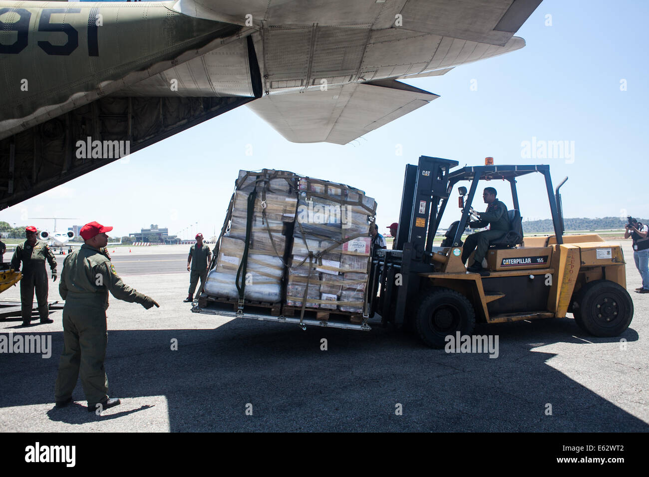 Caracas, Venezuela. 12th Aug, 2014. Venezuelan soldiers move supplies for Palestinians at the international airport of Maiquetia, Caracas, Venezuela, on Aug. 12, 2014. Venezuela Tuesday shipped an initial 12 tons of humanitarian aid to the Palestinians stricken with Israel's offensive in the Gaza Strip, the Venezuelan News Agency (AVN) said. Credit:  Boris Vergara/Xinhua/Alamy Live News Stock Photo