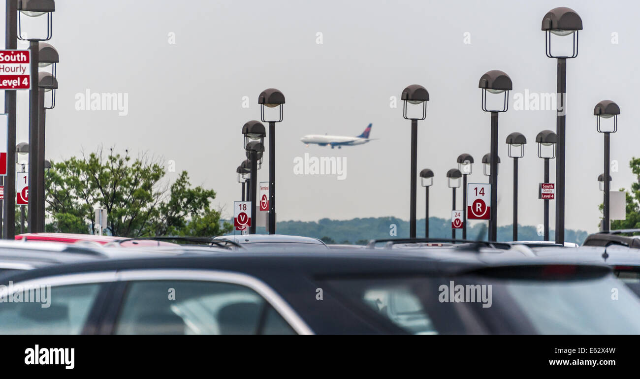 Parking deck at Atlanta International Airport on an overcast day as a Delta Airlines jet approaches for landing. USA. Stock Photo