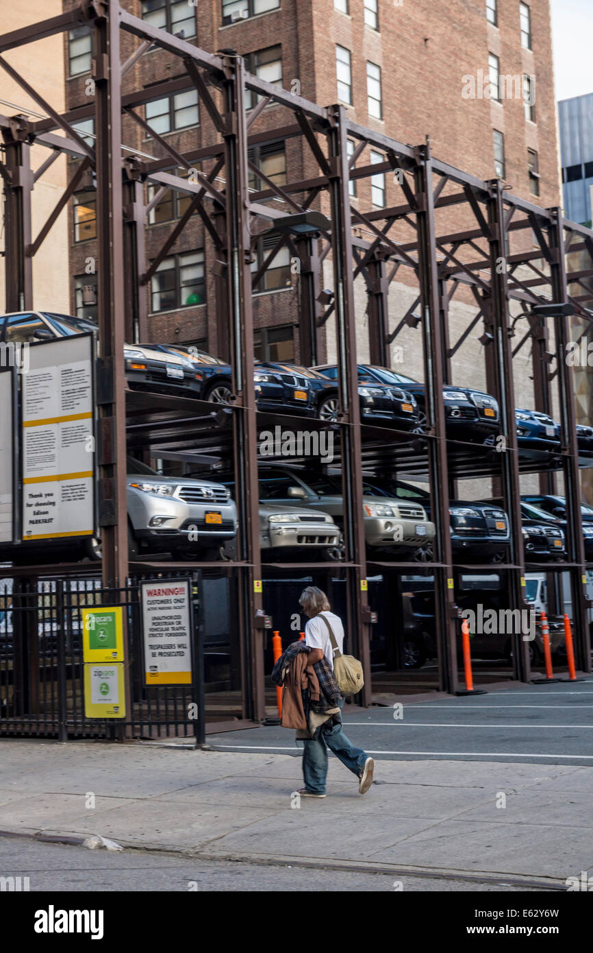 Manhattan, New York. People Pass by multistory parking lot Stock Photo