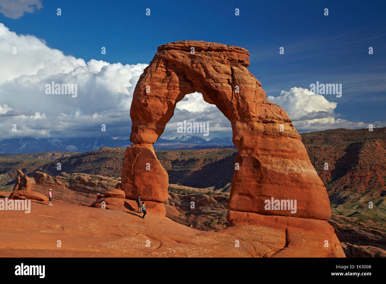 Delicate Arch (65 ft / 20 m tall iconic landmark of Utah), and tourists, Arches National Park, near Moab, Utah, USA Stock Photo