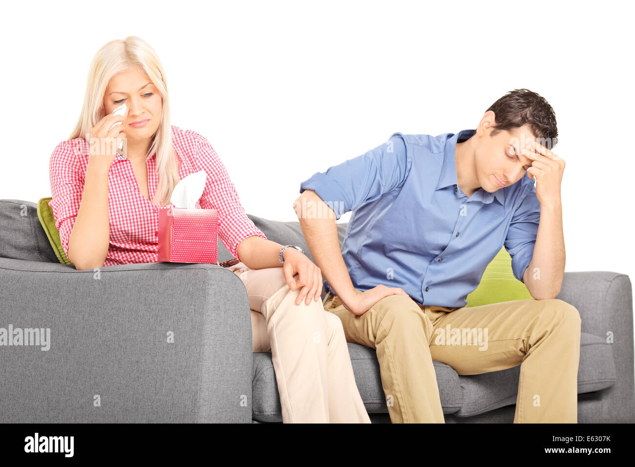 Woman crying after an argument with her boyfriend seated on couch Stock Photo