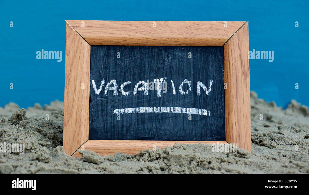 Vacation written on a chalkboard at the beach Stock Photo - Alamy