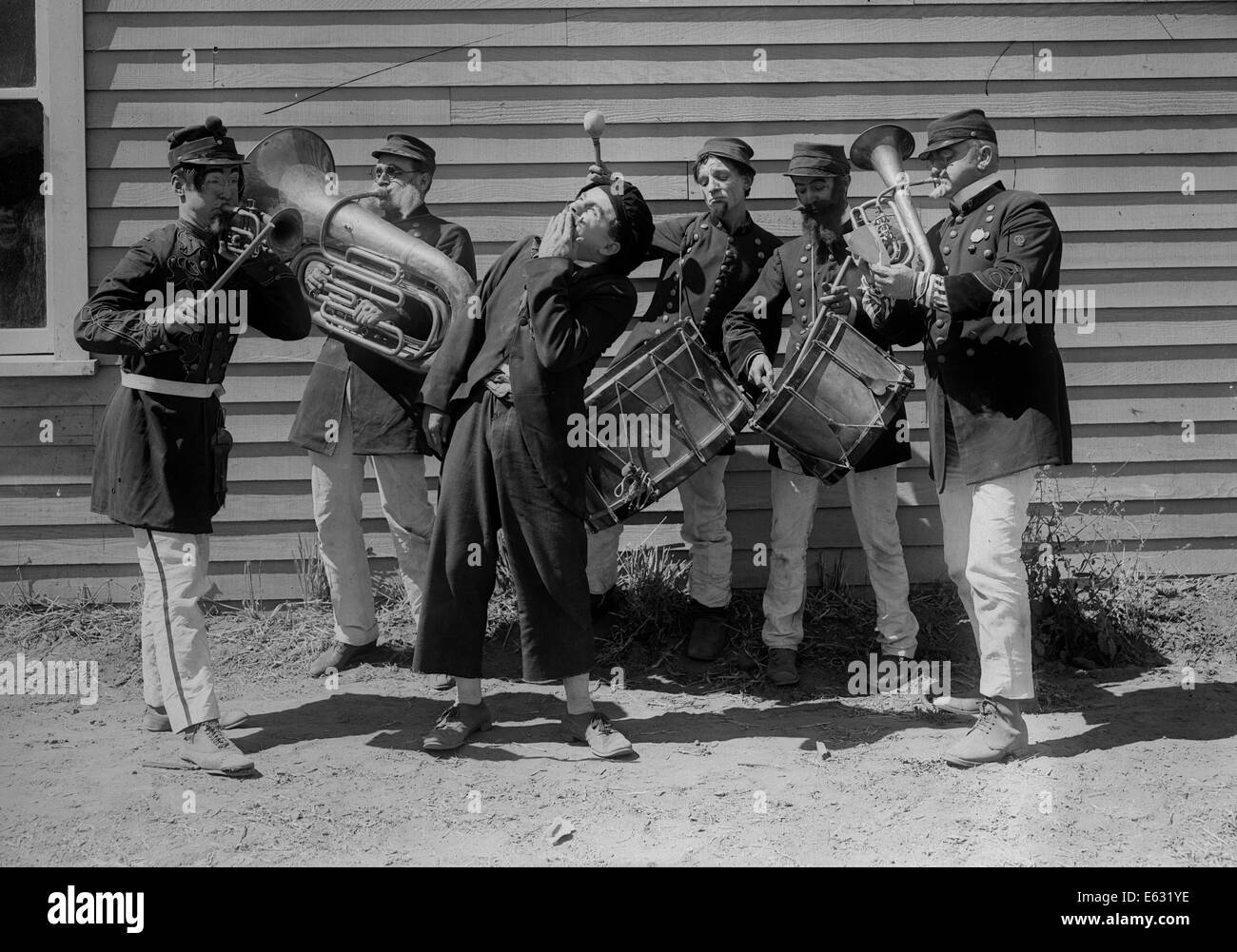 1910s 1920s FUNNY INTOXICATED MAN SINGING SURROUNDED BY MILITARY BRASS BAND SILENT MOVIE STILL Stock Photo