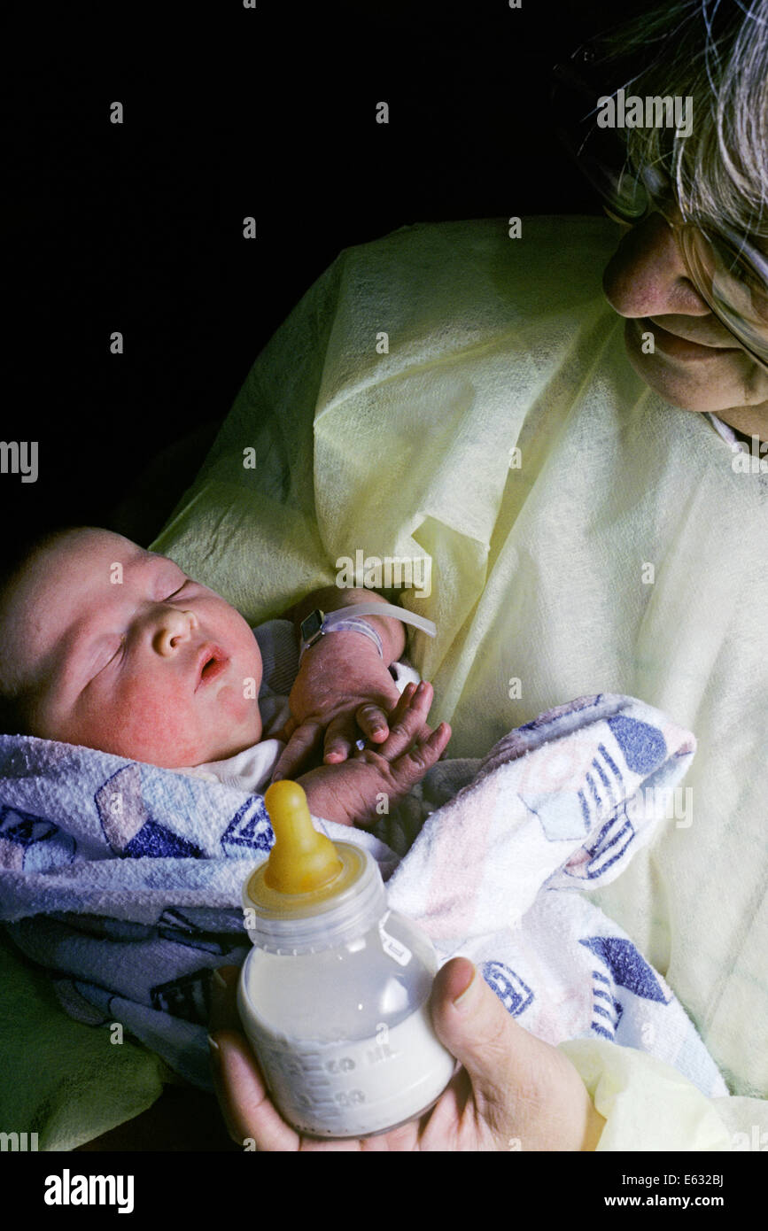 1980s GRANDMOTHER HOLDING SLEEPING INFANT BABY Stock Photo