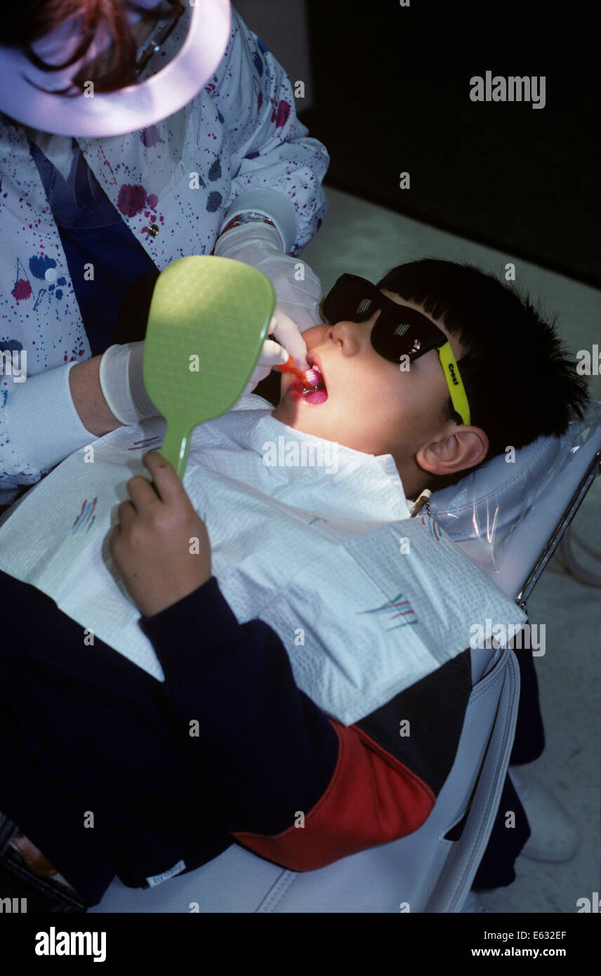 BOY AT DENTIST WEARING SUNGLASSES FOR ULTRAVIOLET PROCEDURE Stock Photo