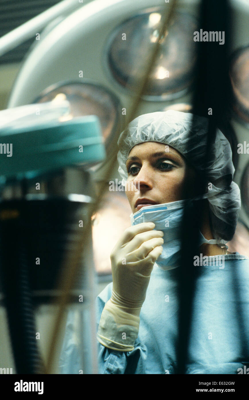 OPERATING ROOM NURSE LOWERING HER SURGICAL MASK Stock Photo