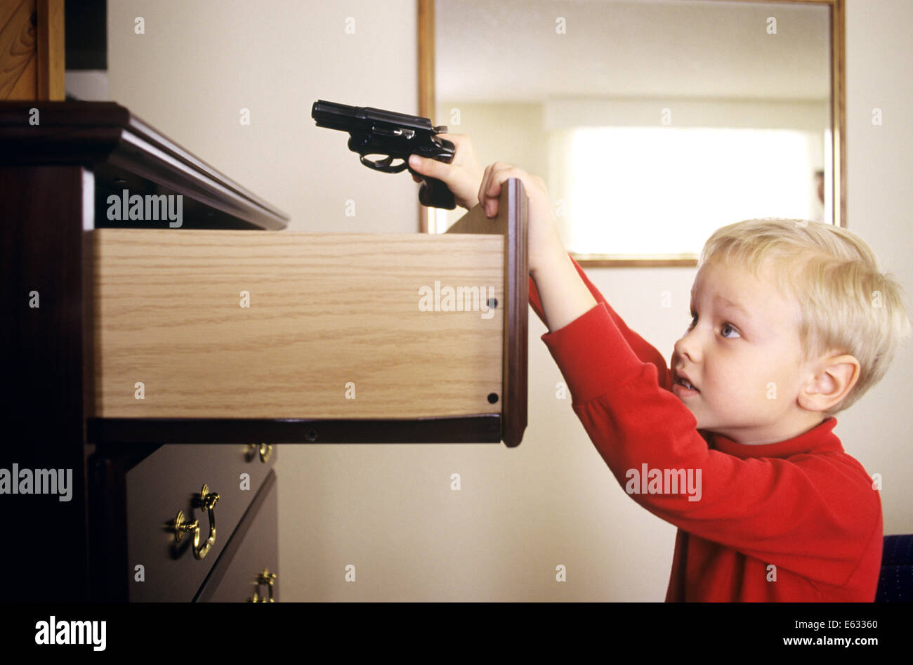 1980s LITTLE BOY FINDING GUN IN DRESSER DRAWER Stock Photo Alamy