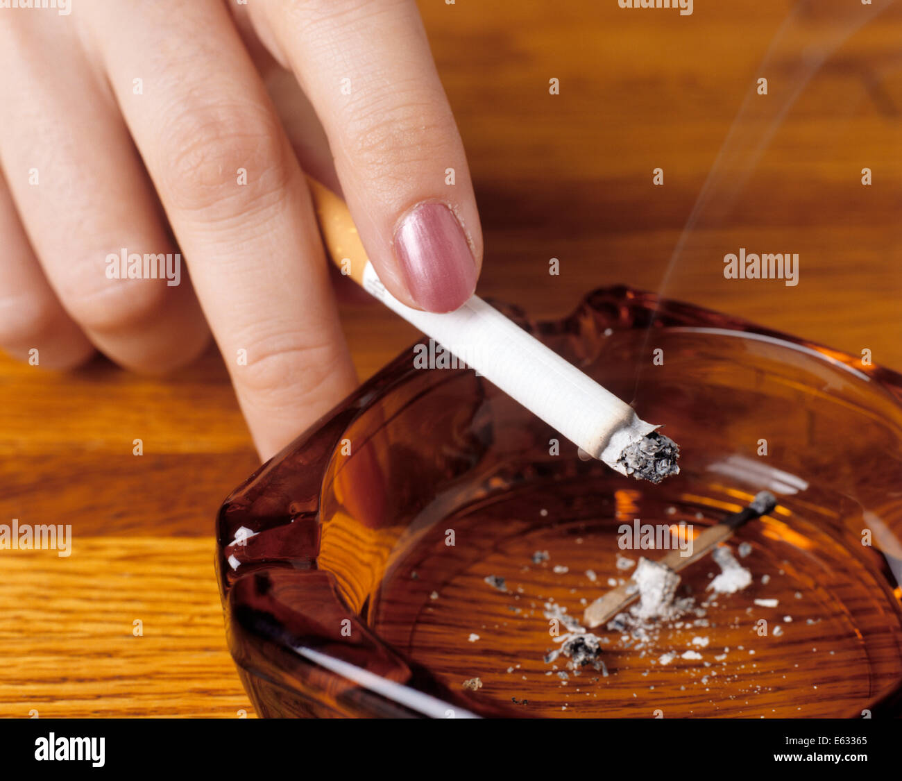 1990s WOMAN'S HAND HOLDING A CIGARETTE OVER AN ASHTRAY Stock Photo Alamy