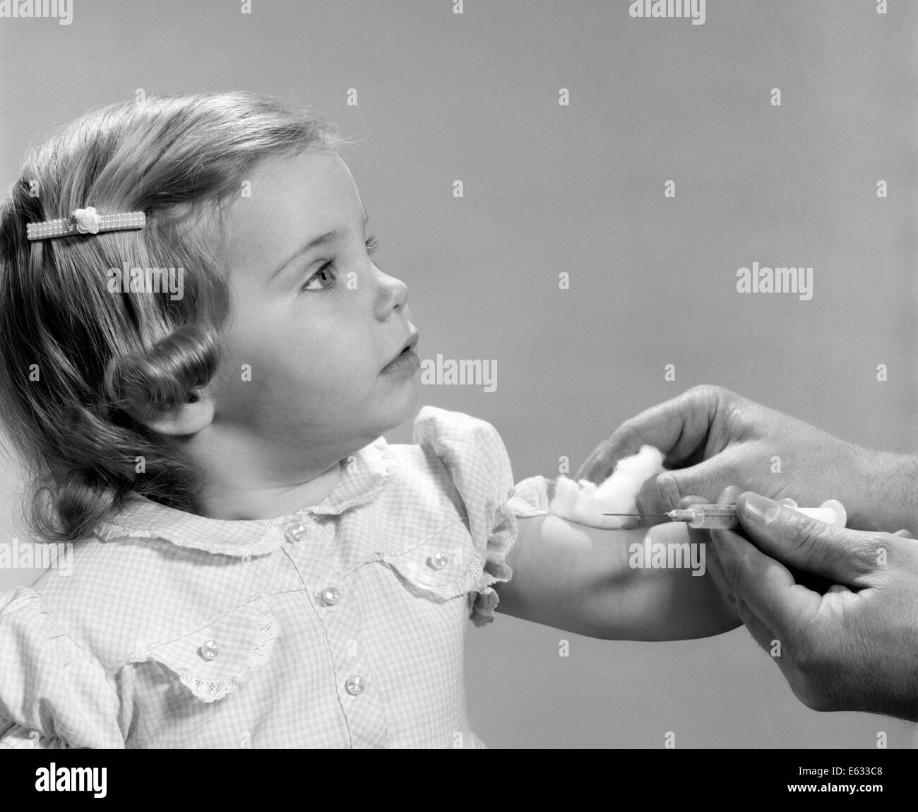 1960s 1960s LITTLE GIRL GETTING SHOT HYPODERMIC NEEDLE VACCINATION INJECTION IMMUNIZATION VACCINE Stock Photo