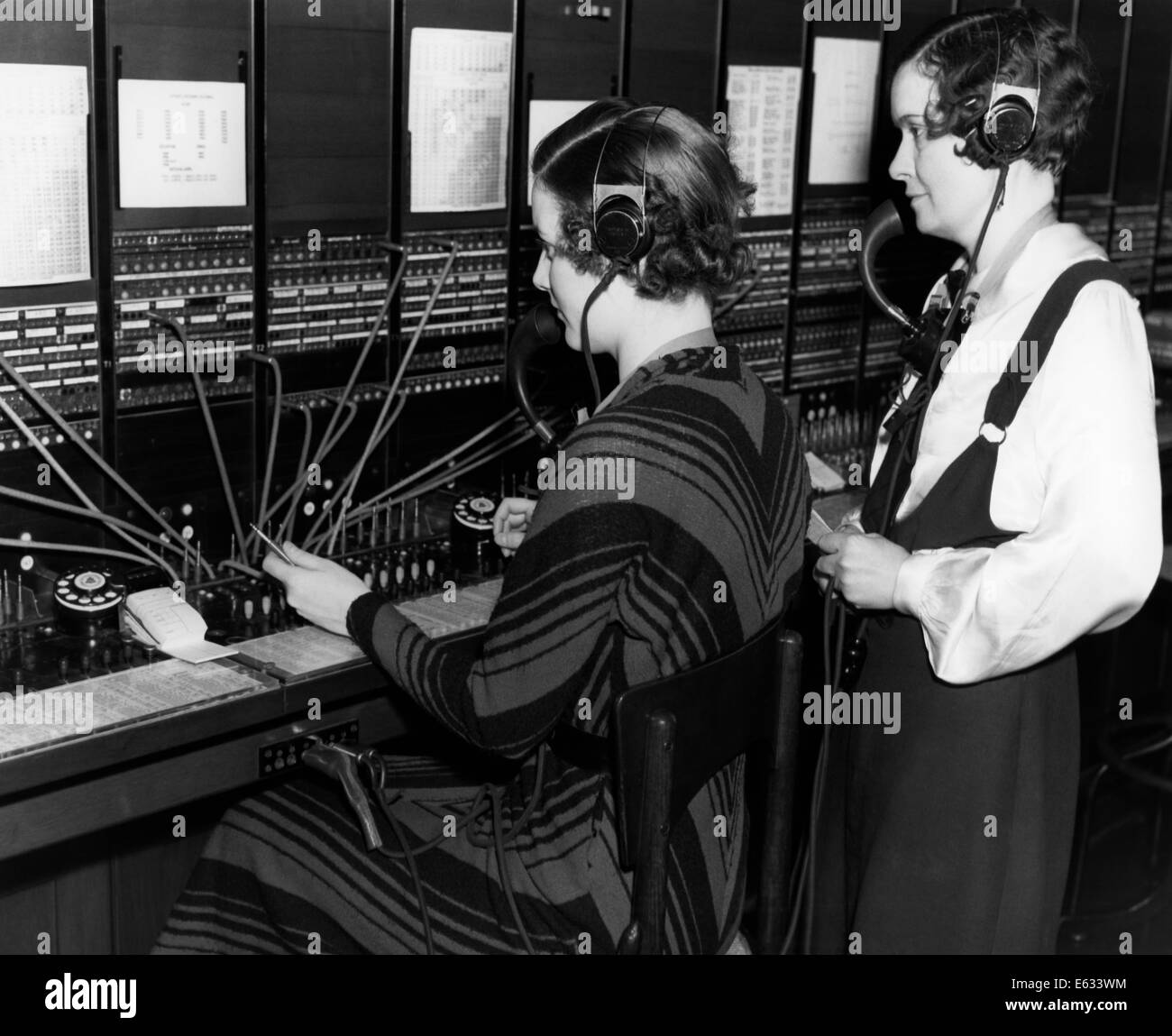 1930s FEMALE TELEPHONE SWITCHBOARD OPERATOR AND SUPERVISOR Stock Photo
