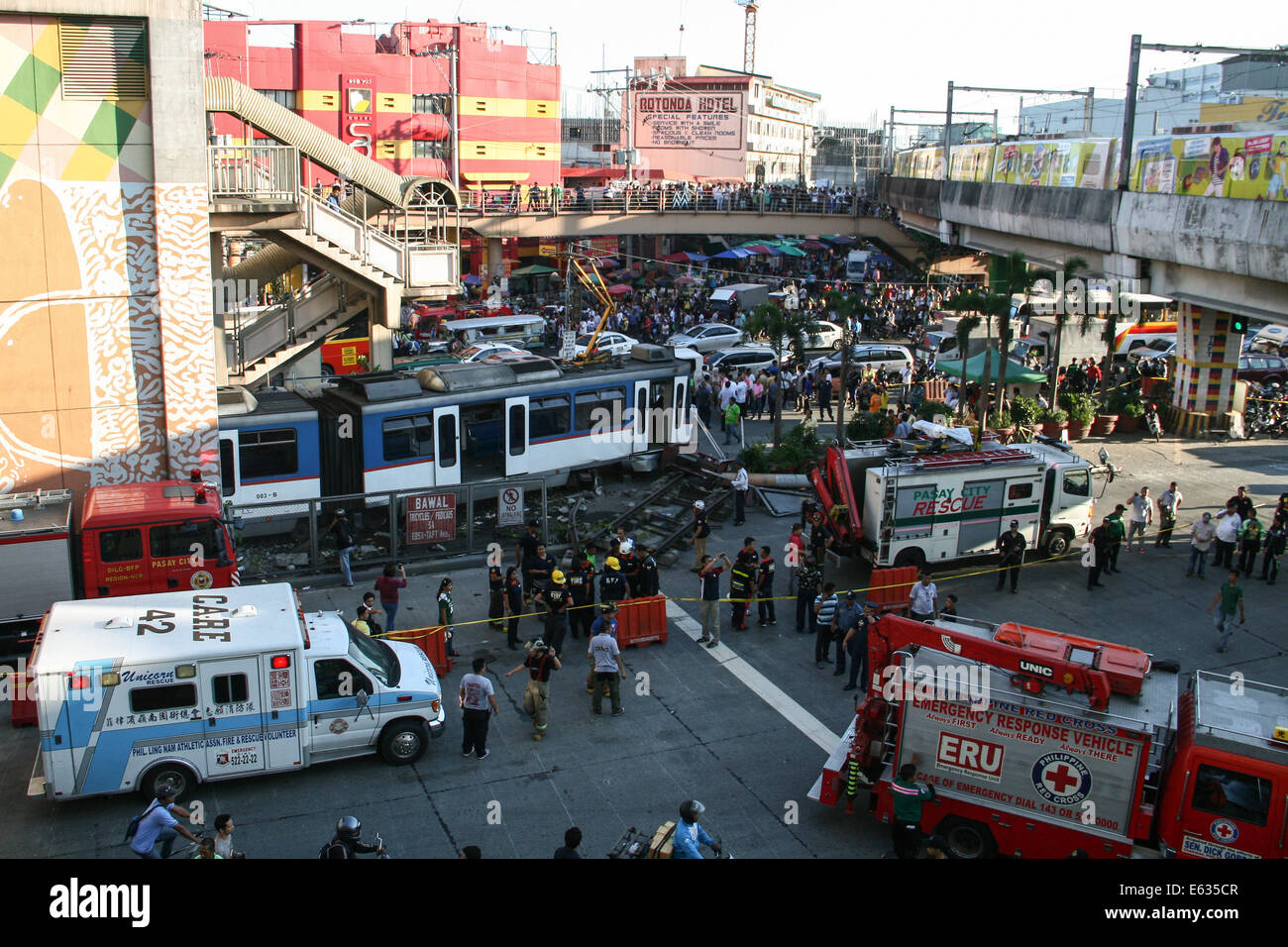 Pasay City, Manila, Philippines. 13th August, 2014. Rescue vehicles surround the MRT train that overshot the barrier as it failed to make its stop at the Pasay Rotonda Station. A three coach train failed to stop at its final station overshooting the barrier and causing injury to its passengers. According to initial reports, about 50 incurred injuries but there was no reported fatalities. Credit:  J Gerard Seguia/Pacific Press/Alamy Live News Stock Photo