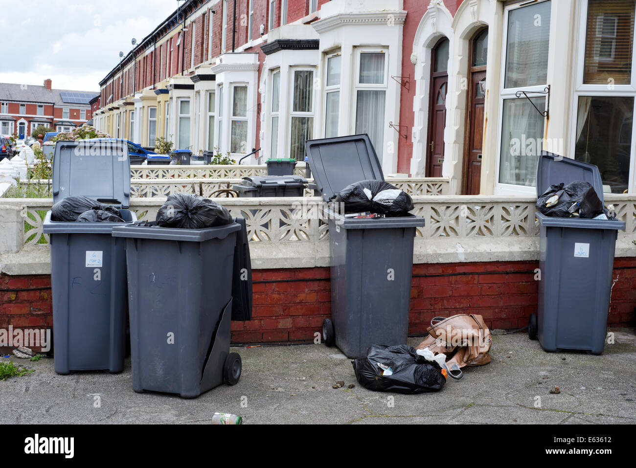 Several overflowing wheelie bins outside a house in a suburban street Stock Photo