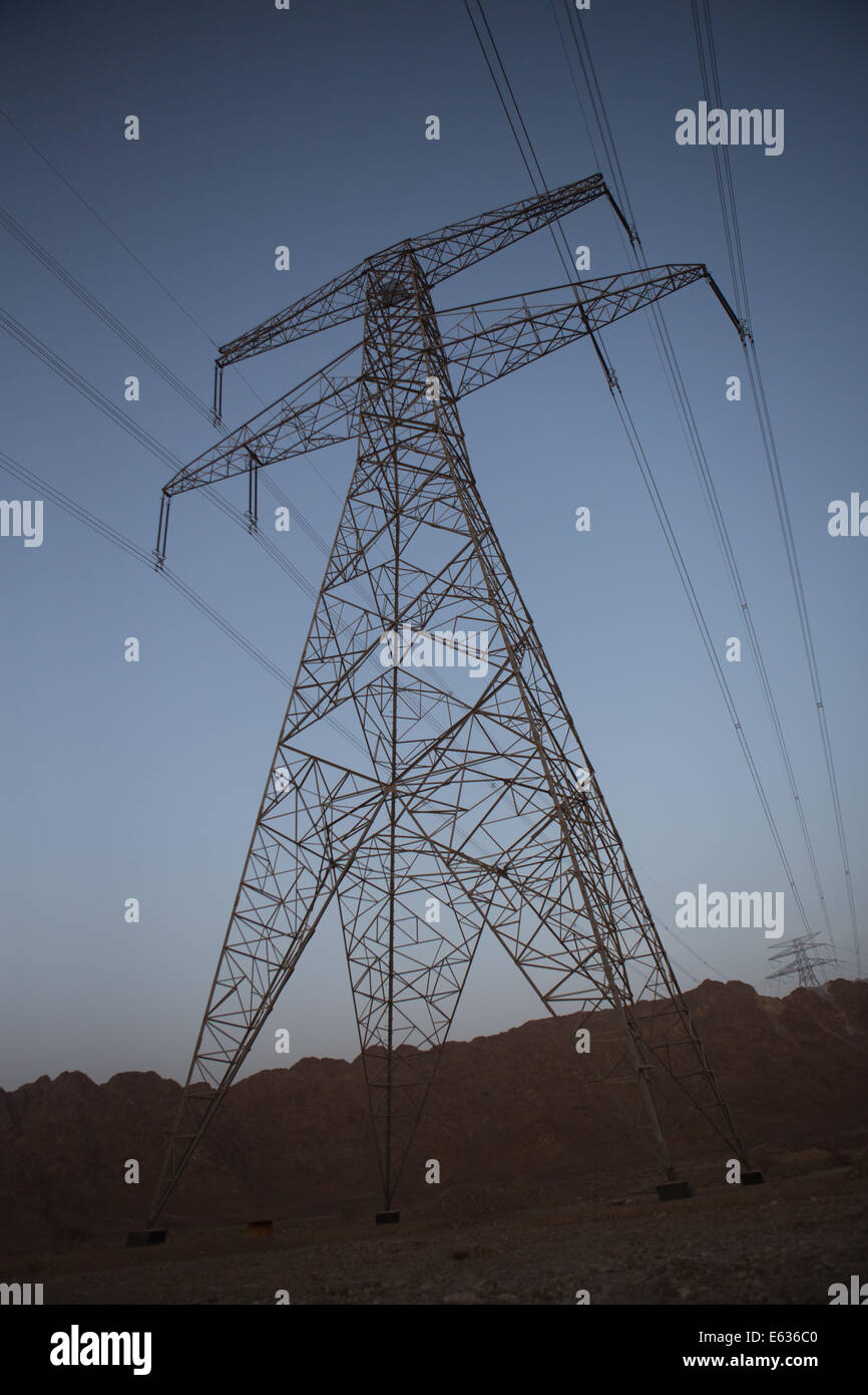 Electricity pylon looms overhead at dusk, Dibba, Fujairah, United Arab