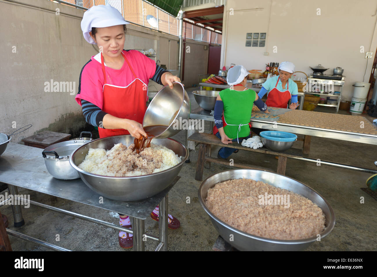 Lampang, Thailand - February 12, 2014: Women making deep-fried cakes drizzled with palm sugar in Lampang, Thailand Stock Photo