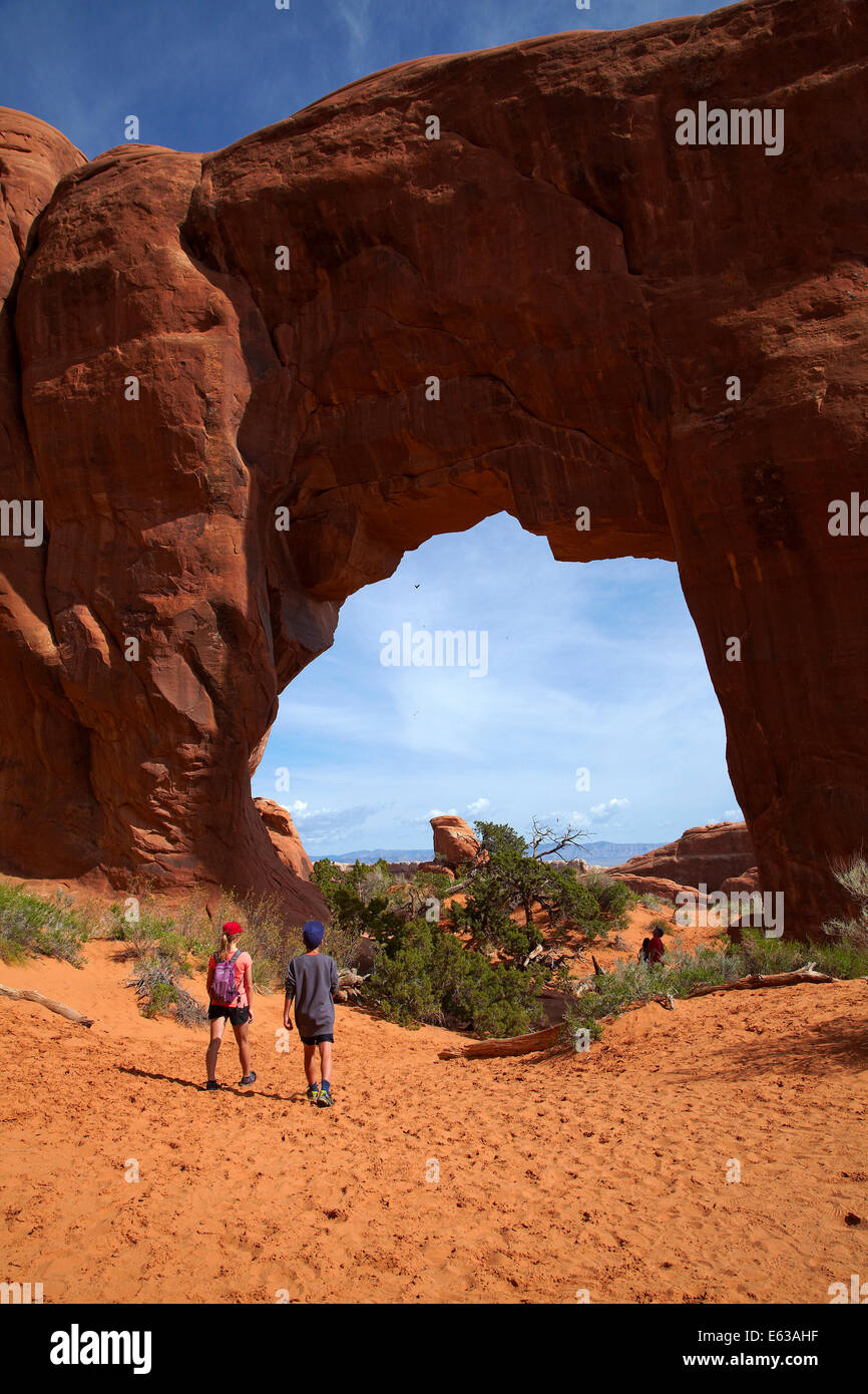 Hikers and Pine Tree Arch, Devil's Garden area of Arches National Park, near Moab, Utah, USA Stock Photo