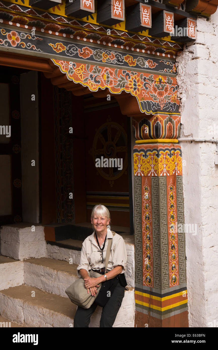 Eastern Bhutan, Lhuentse, Rinchentse Phodrang Dzong western tourist sitting under decorated door Stock Photo