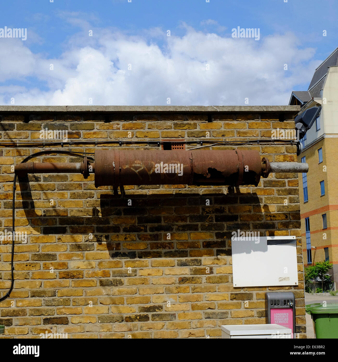 rusty fume exhaust vent on side of Garage Stock Photo