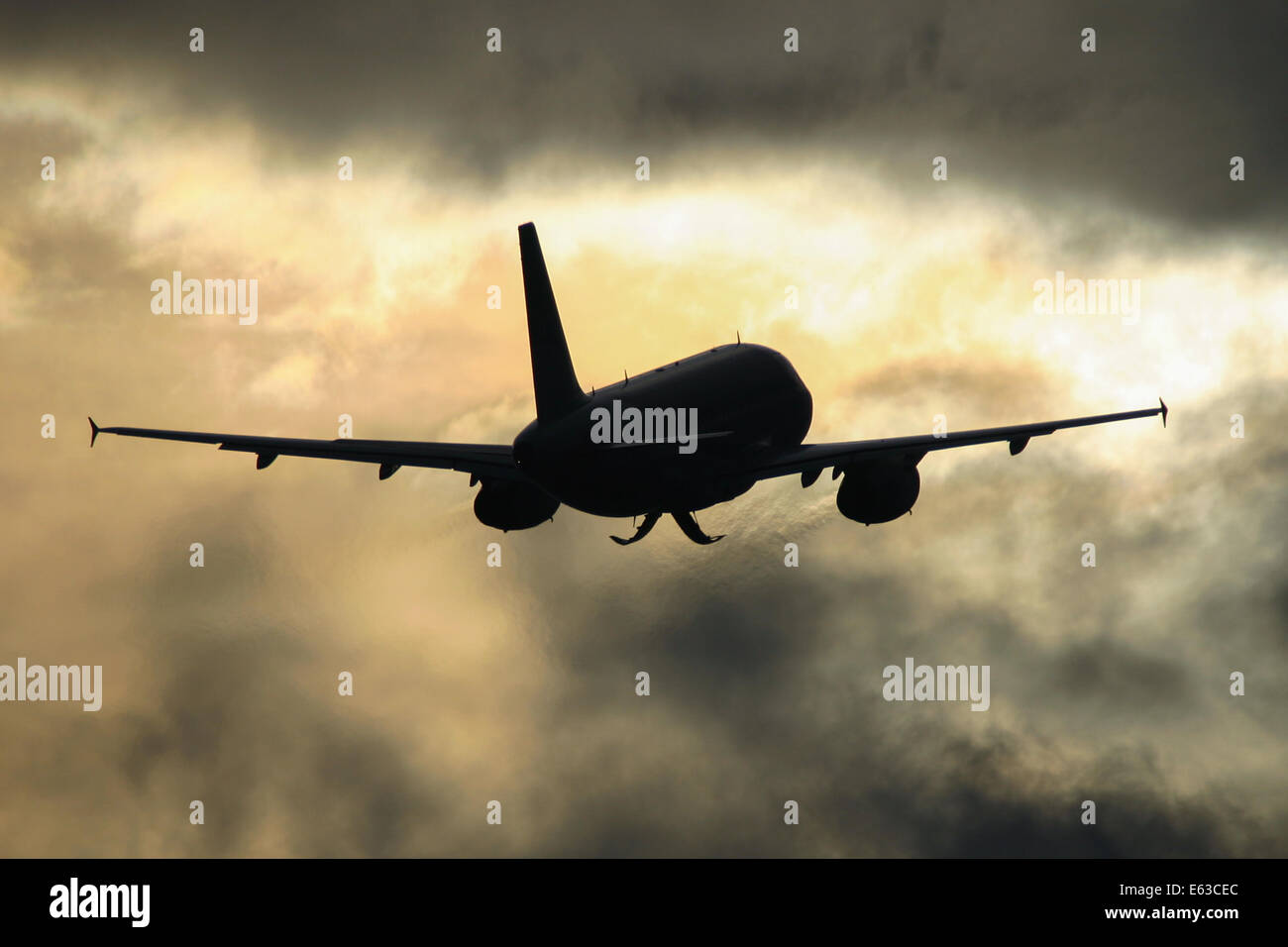 bmi British Midland Airbus A319 climbs from runway 23R at Manchester airport, into the low winter sun. Stock Photo