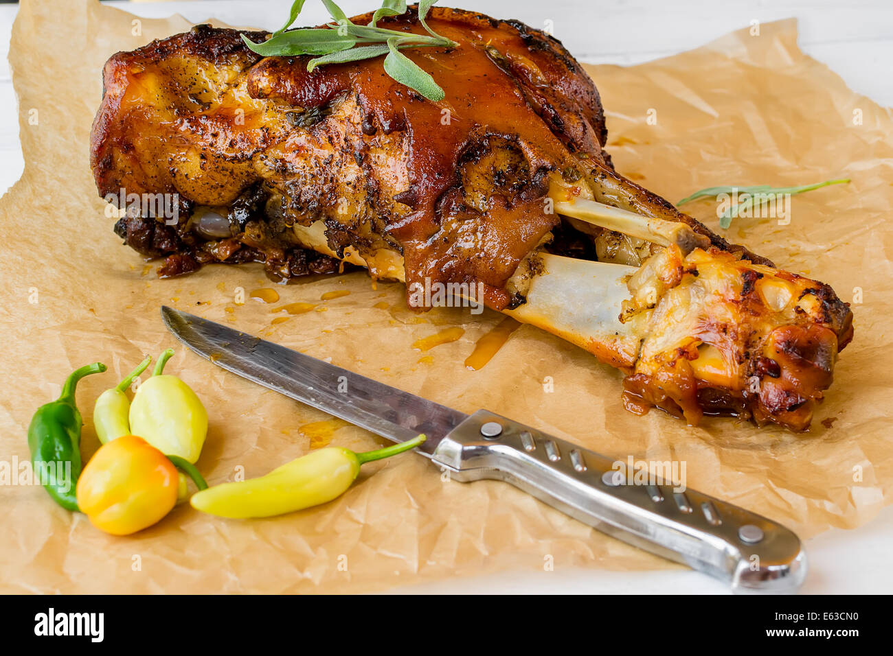 Knuckle baked with a toasted skin, potatoes and chillies Stock Photo