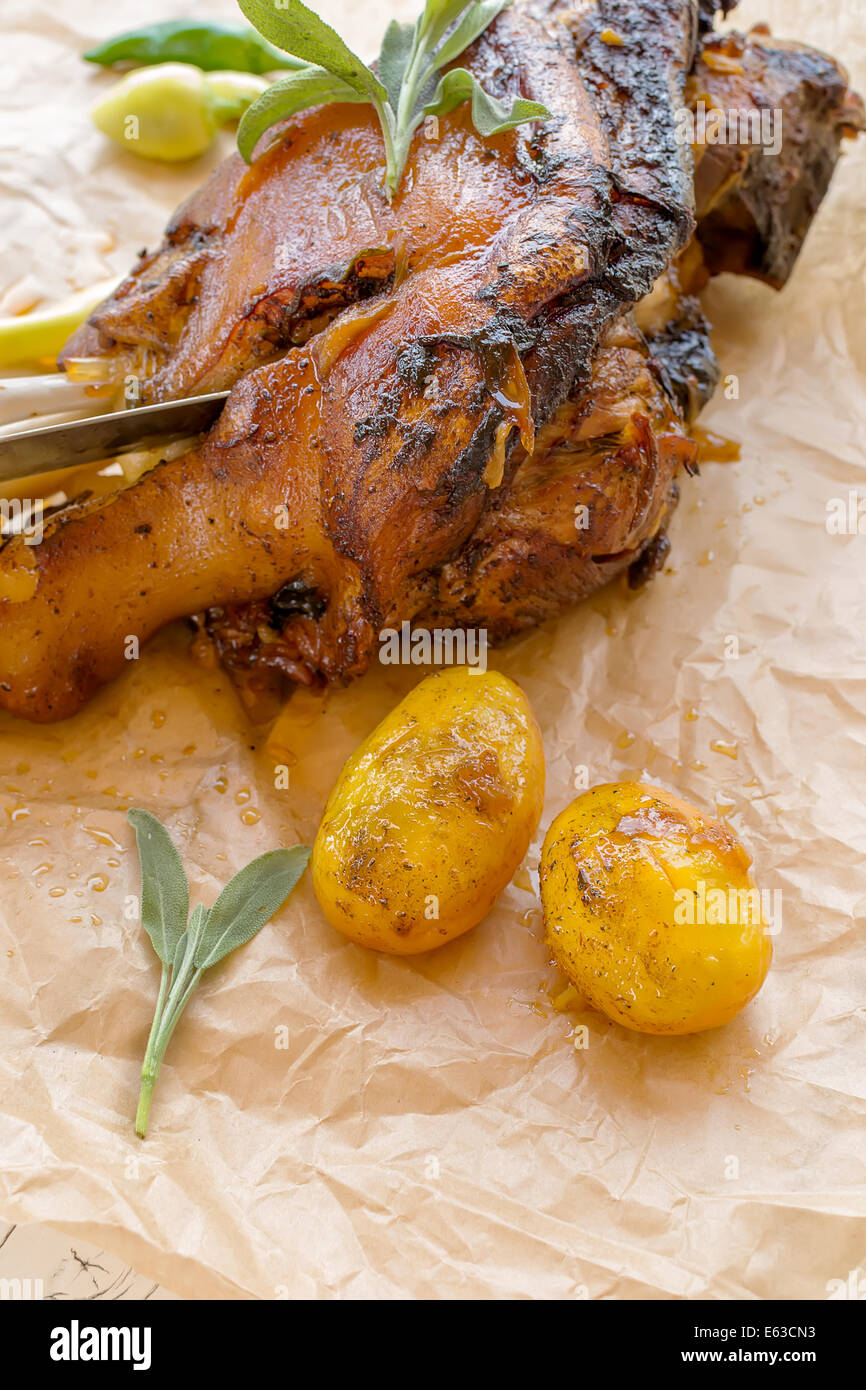 Knuckle baked with a toasted skin, potatoes and chillies Stock Photo