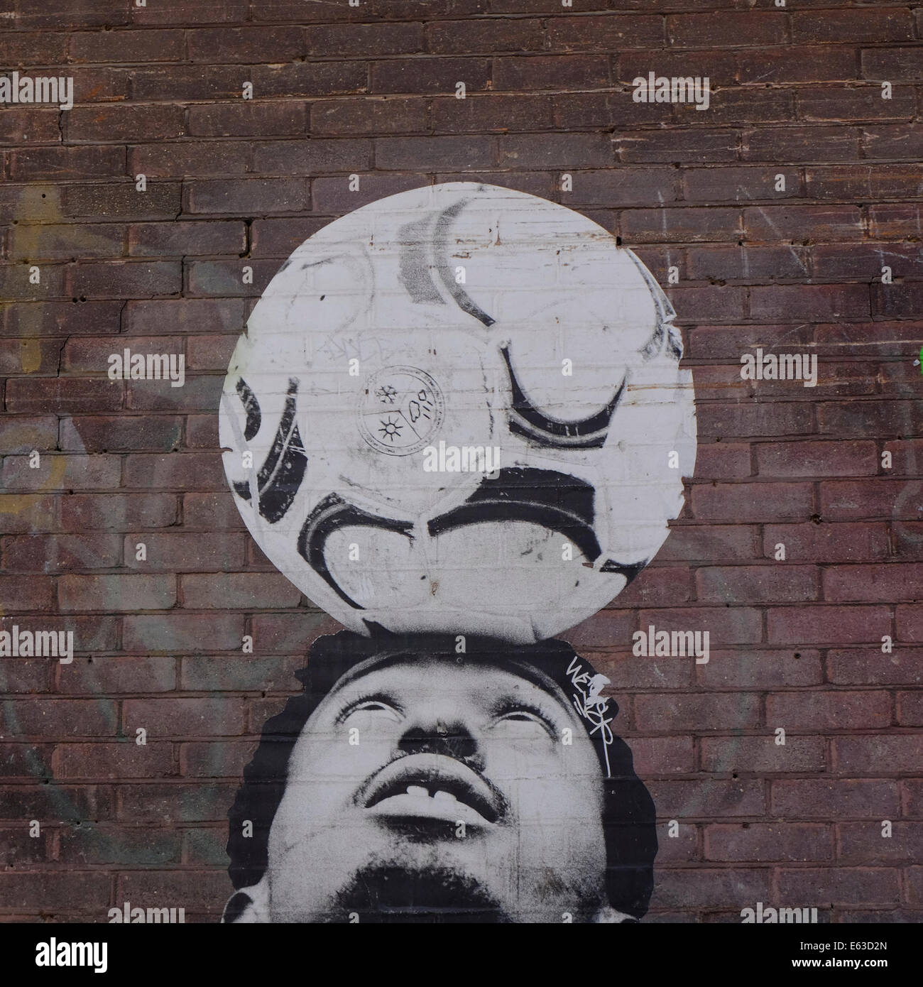Football on head street art in Shoreditch, London Stock Photo
