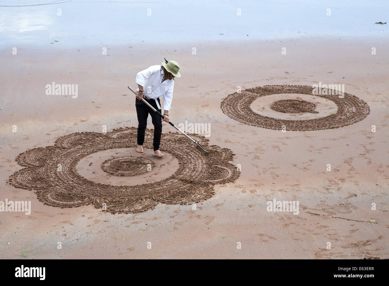 Man doing sand art on the beach Stock Photo