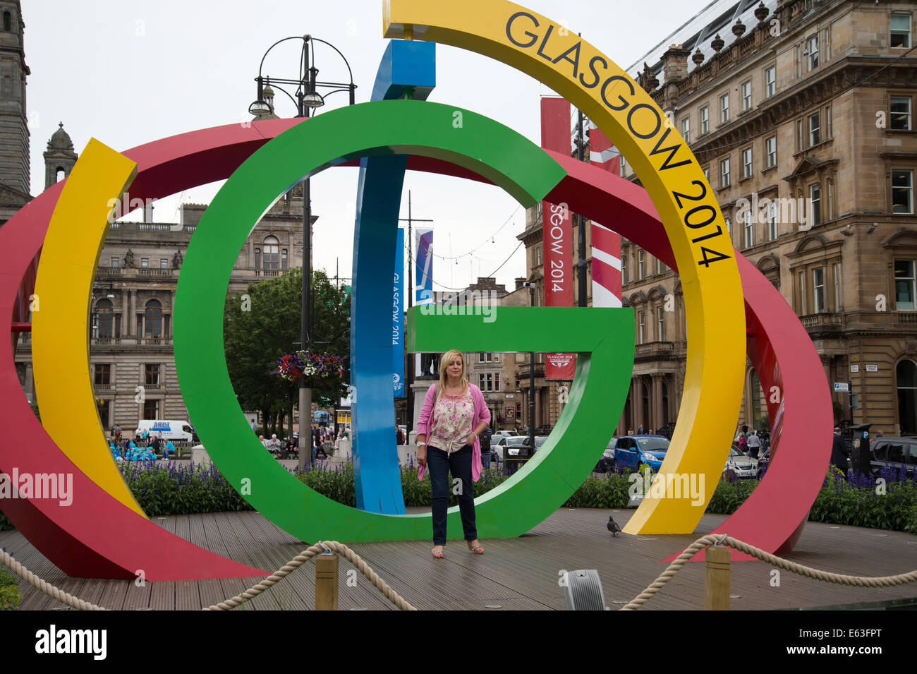 Scotland 2014. Glasgow. A woman has her photo taken in front of the symbol for the Commonwealth Games Stock Photo