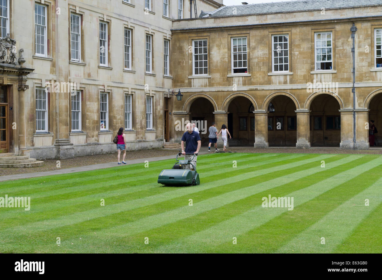 Gardener mowing the lawn within Emmanuel College, Cambridge, UK Stock Photo