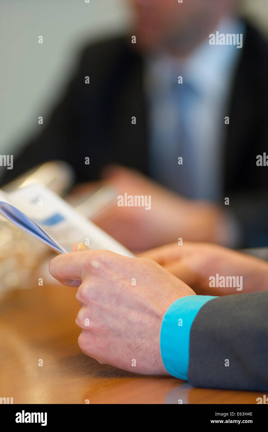Male hand holding documents with both hands in an office during a