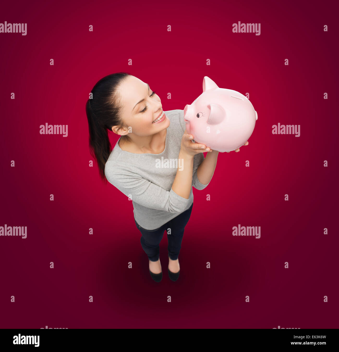 happy woman looking at piggy bank Stock Photo - Alamy