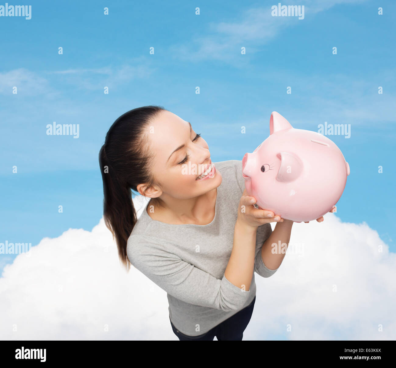 happy woman looking at piggy bank Stock Photo - Alamy