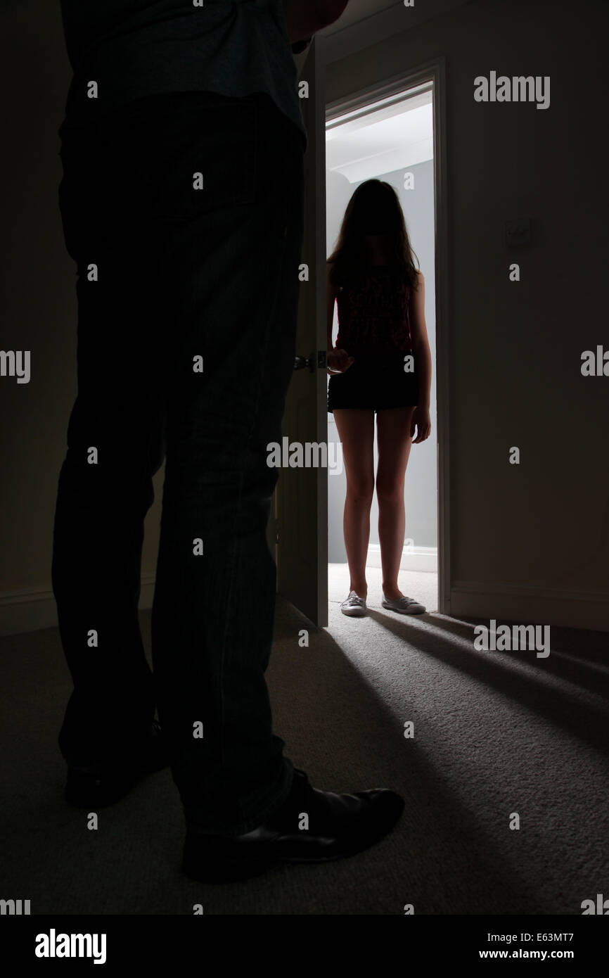 Unrecognisable silhouette of a girl standing in a doorway. Stock Photo