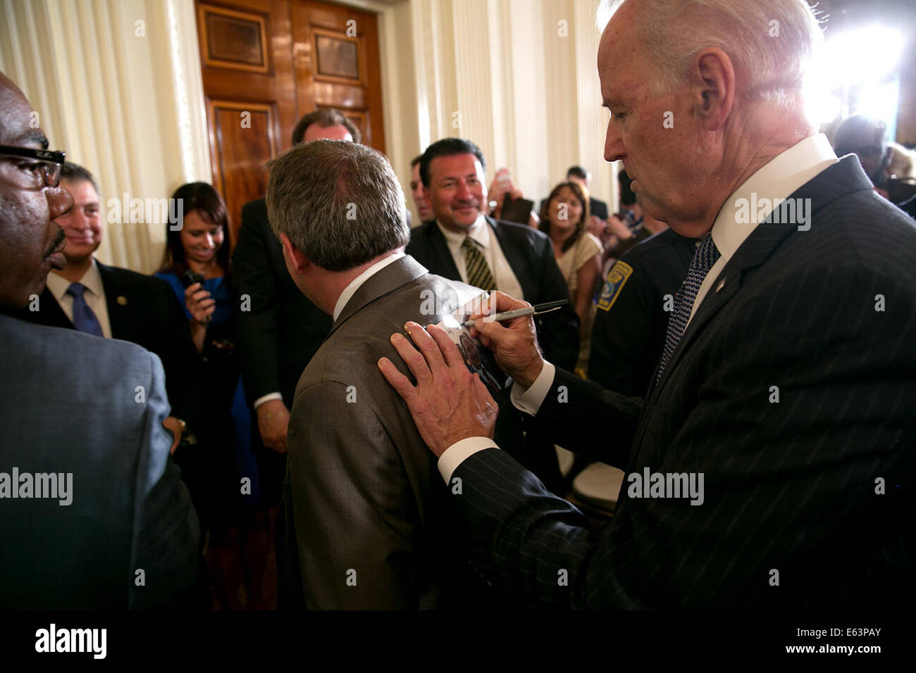 Vice President Joe Biden inscribes a photograph after honoring the 2014 National Association of Police Organizations Top Cops award winners in the East Room of the White House, May 12, 2014. Stock Photo