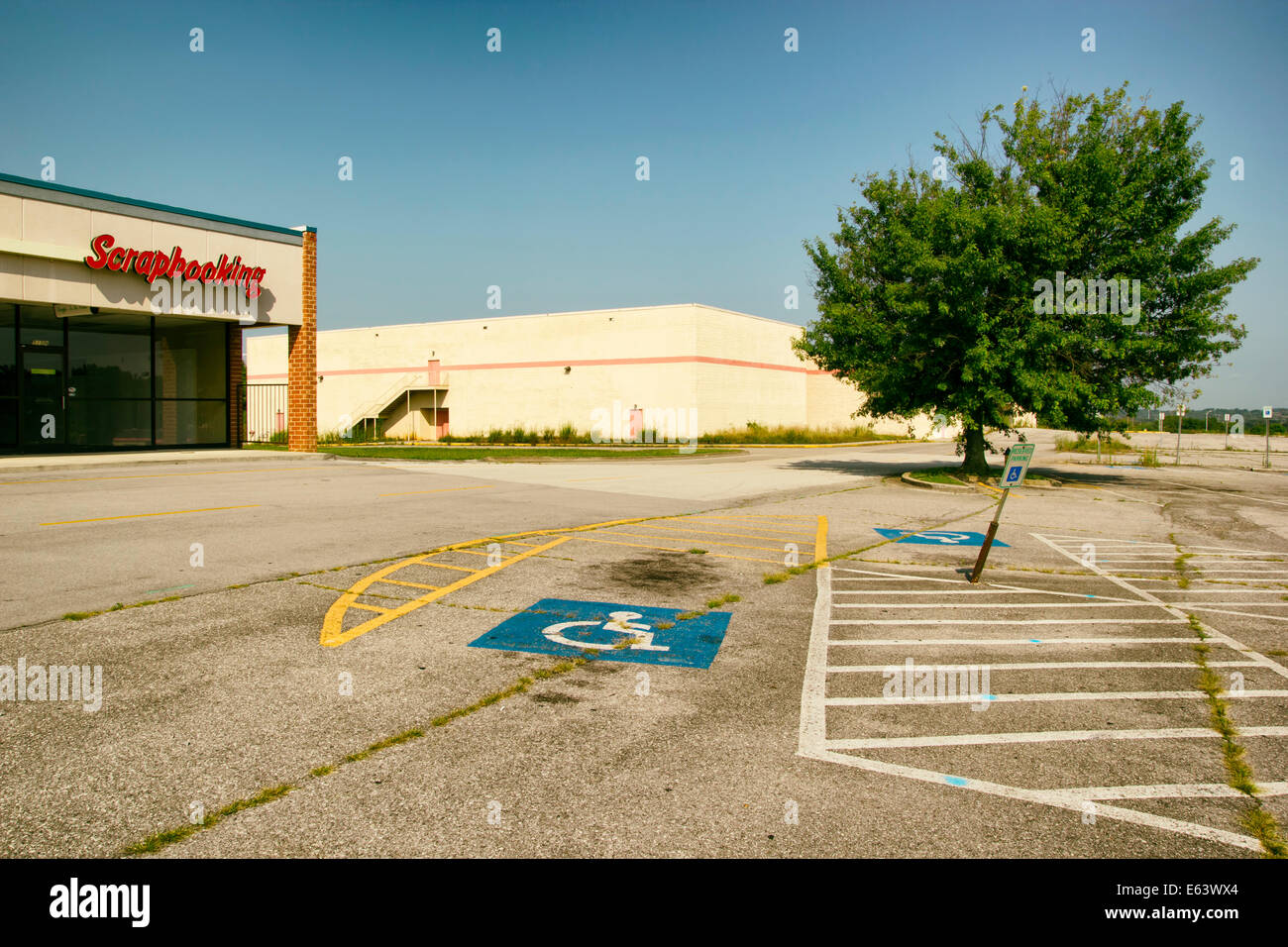 Abandoned strip mall and movie theater with a large empty parking lot. Stock Photo