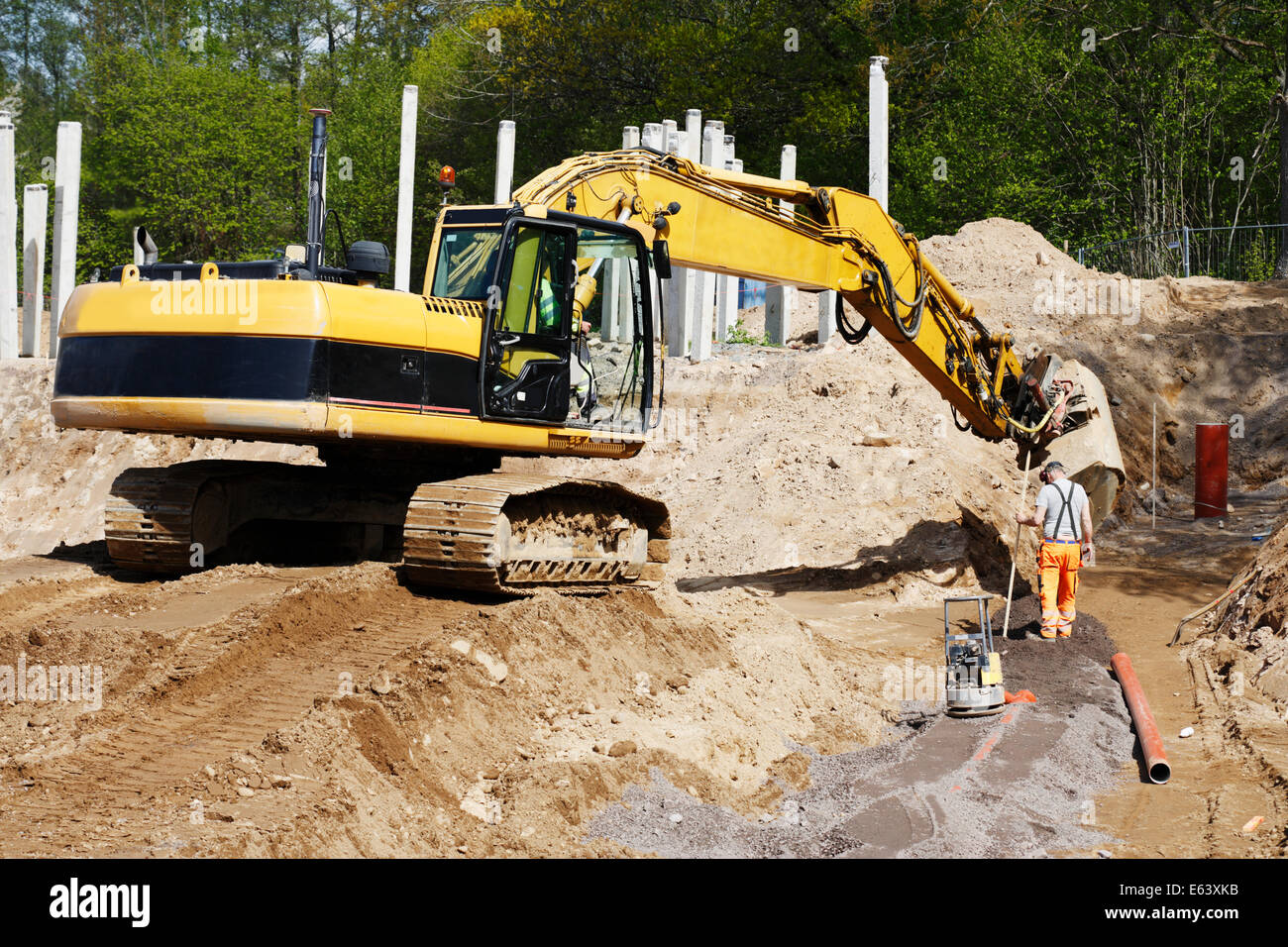 bulldozer, digger and site-worker in action, road-works Stock Photo