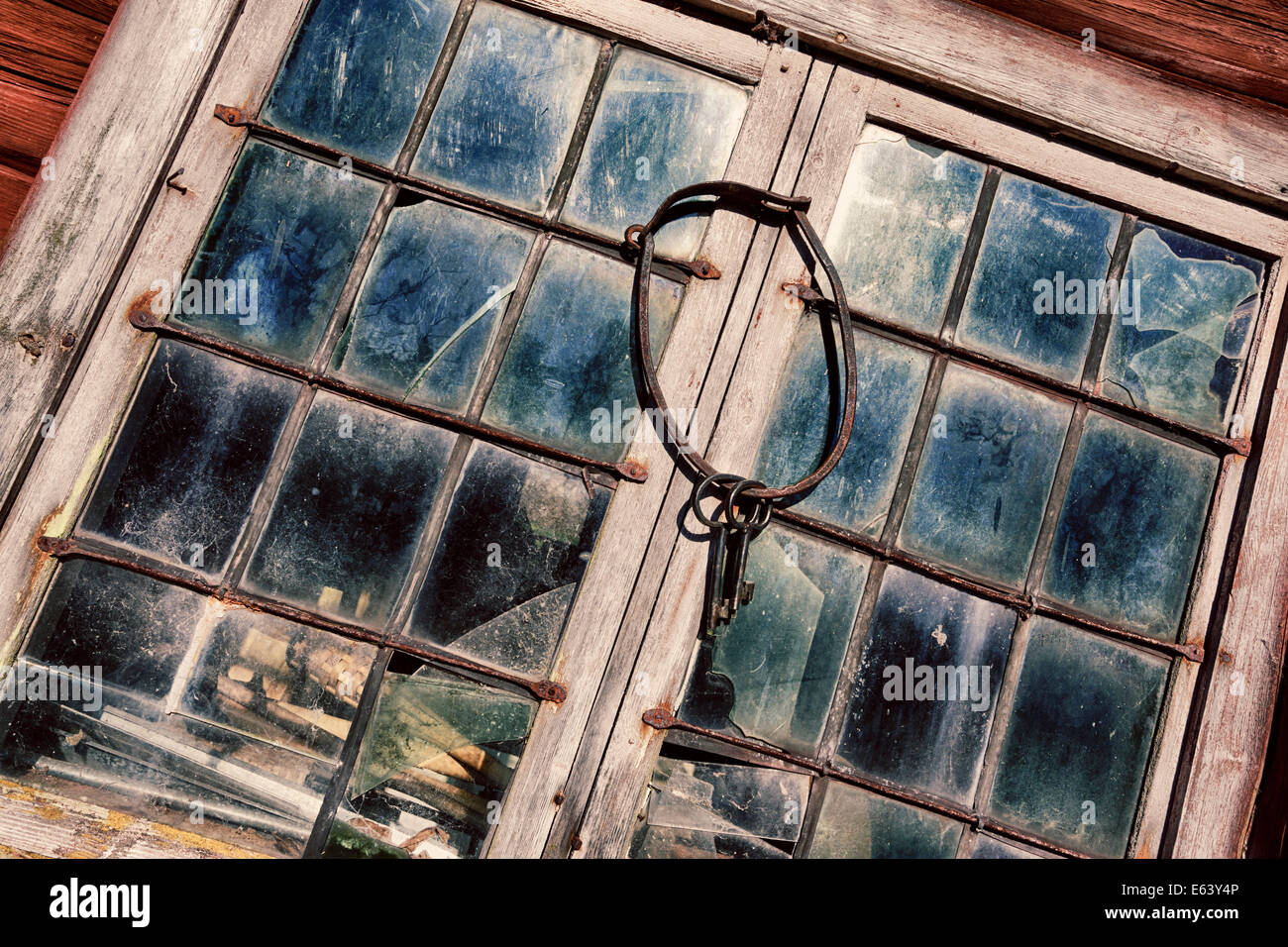 old, antique keys and ring hanging against leaded stained windows and frames, 17th century concept Stock Photo