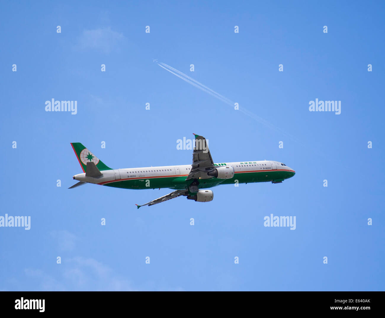 A commercial airplane operated by Taiwanese airlines EVA Air is taking off from the Songshan airport while another commercial airplane is flying over. On July 26, 2014 in Taipei, Taiwan. (CTK Photo/Karel Picha) Stock Photo