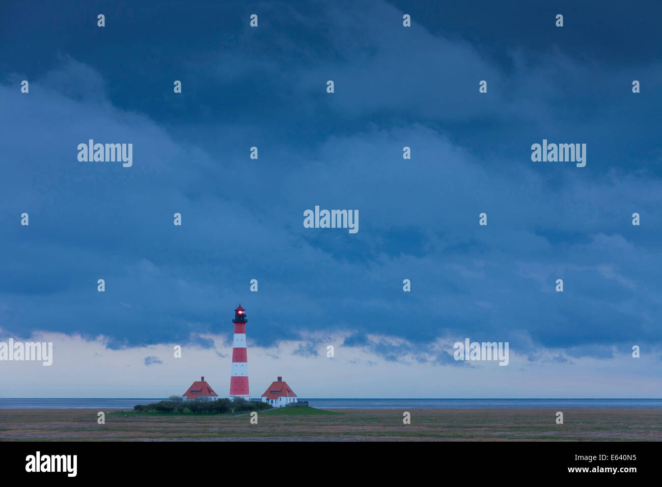 The lighthouse Westerheversand with storm clouds. Peninsula of Eiderstedt, North Frisia, Germany Stock Photo