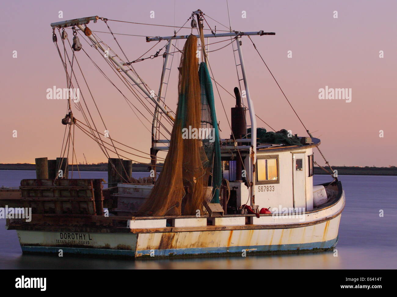 A shrimp boat (trawler) at rest on a tranquil bay in Texas, USA. Stock Photo