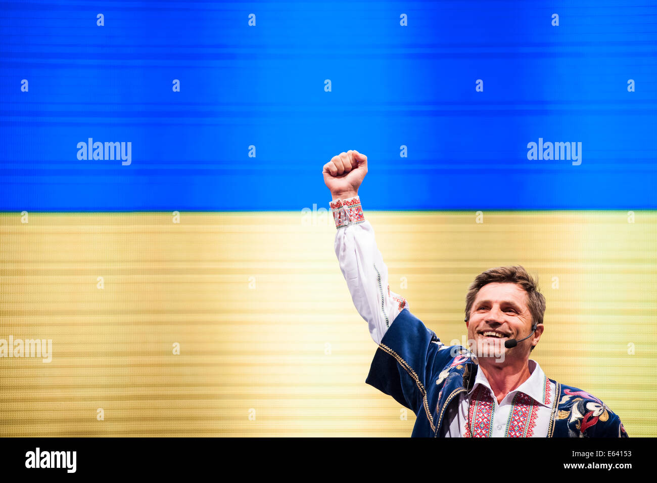 A Ukrainian folk singer with his right fist in the air, with Ukrainian ...
