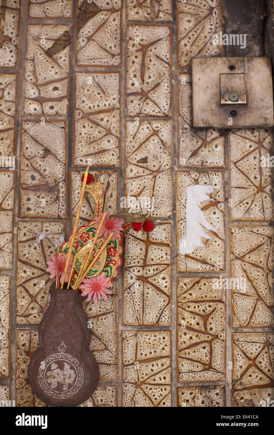 A small incense holder hangs on a patterned wall, Chinatown, Bangkok, Thailand Stock Photo