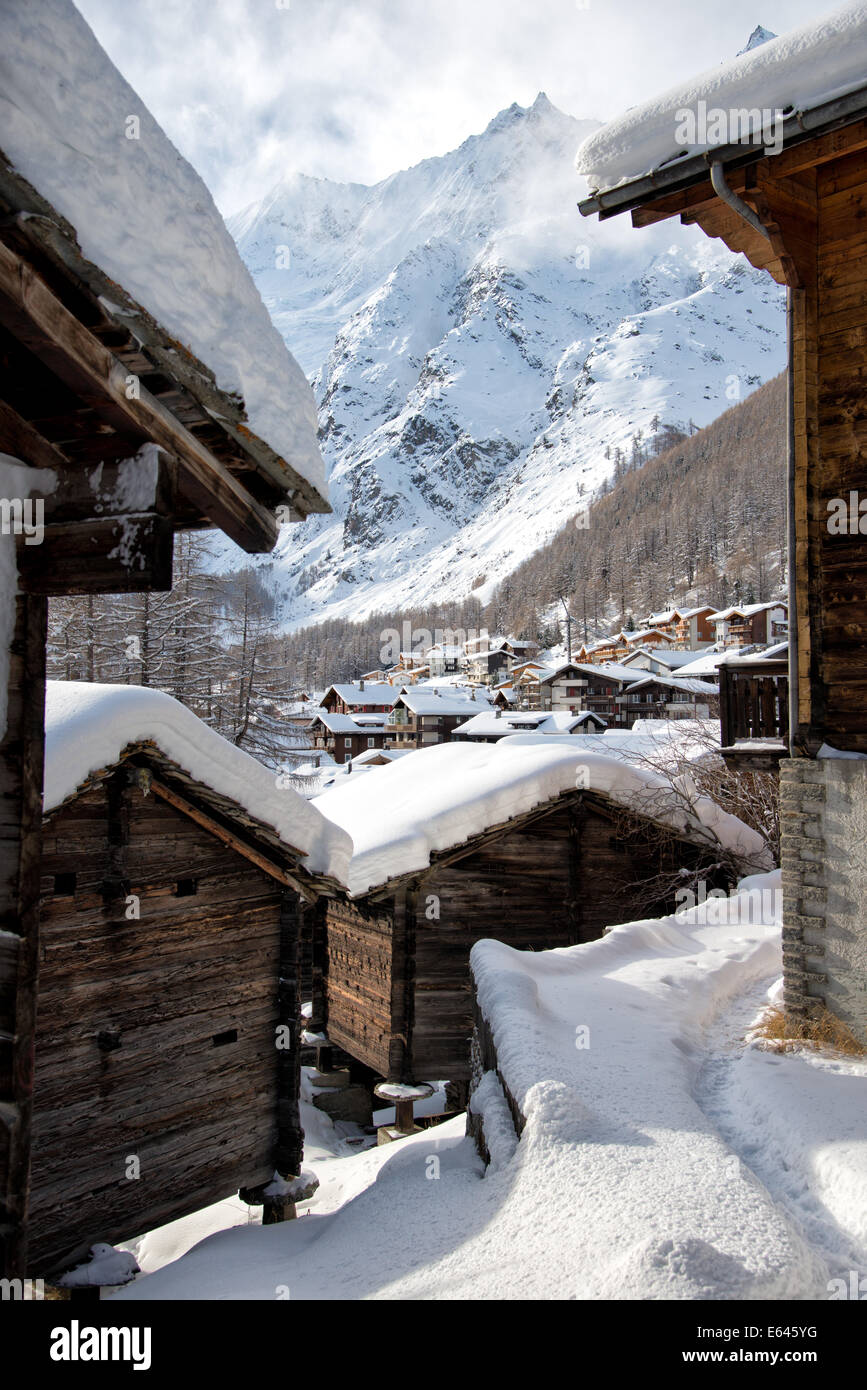 View of the Swiss Alpine village of Saas-Fee in the Winter, with its wooden houses with snow covered roof. Stock Photo
